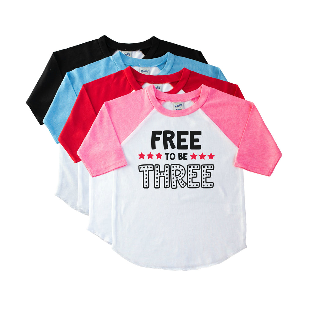 Pink toddler raglan with Free to be Three in black with red stars on the front