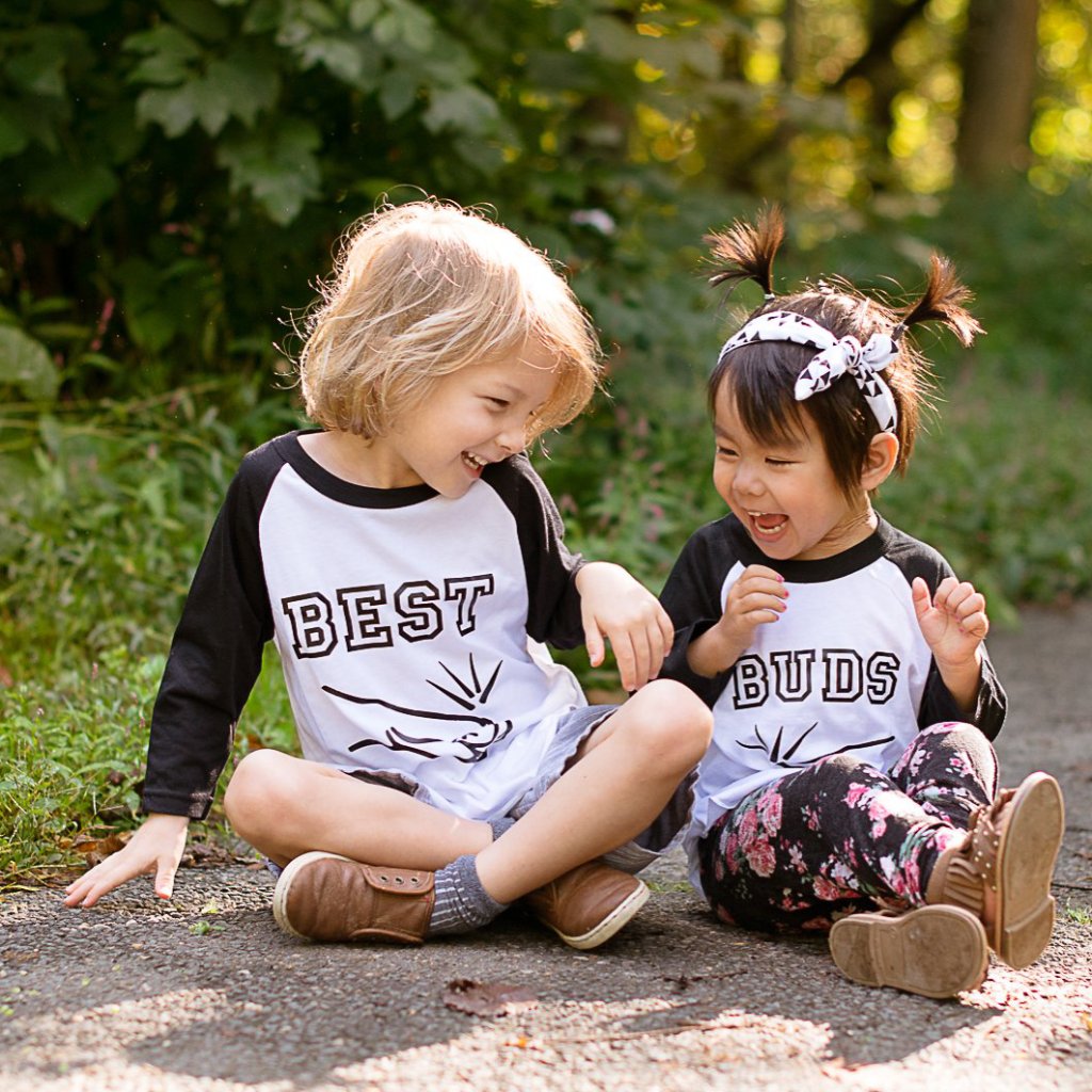 Little boy and girl sitting wearing black sleeve best buds fist bump raglan shirt set