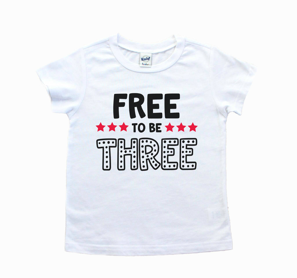 White short sleeve shirt with black Free to be Three writing and red star accents
